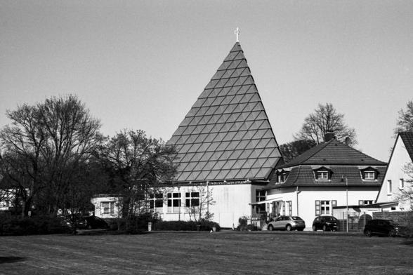 Black and white photo of a modernist church building with a roof shaped like a tetrahedron