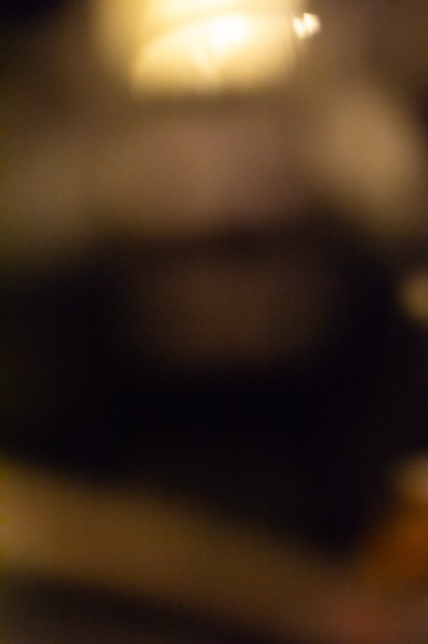 Defocused dark forms float in a murky brown and gold.
