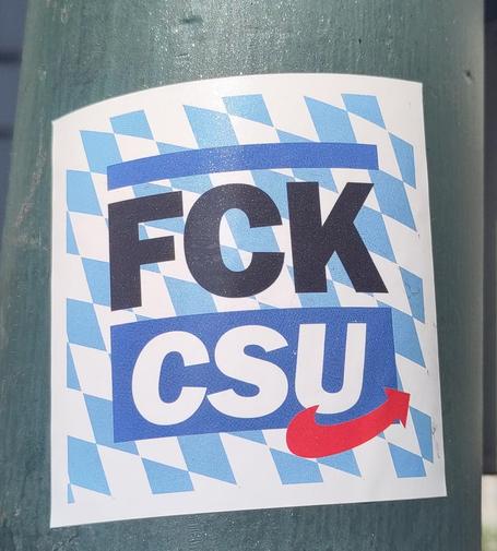 Aufkleber, der den Schriftzug "FCK CSU" zeigt. Beim Parteinamen befindet sich außerdem der spezielle rote Pfeil, den sonst nur die AfD verwendet. Im Hintergrund sind blau-weiße Rauten im Stil der Fahne Bayerns
