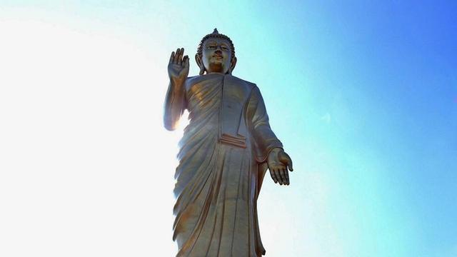 Giant golden standing Buddha statue.
