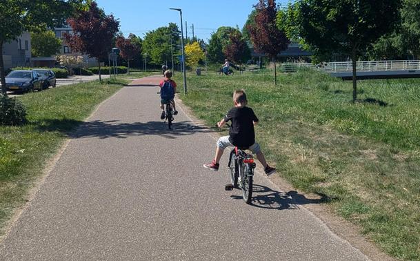 two kids on bicycles on a bike path