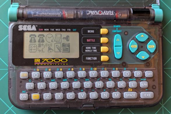 The front of the PDA. The screen is on and displaying icons like a phone book, world clock calculator,  IR communicator etc. 

The shell is a translucent gray. With various buttons in Gray, yellow and turquoise.
