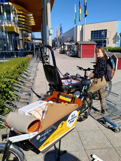 Ju mit einem elektrischen Douze-Lastenrad von Frieda & Friedrich, davor ein nicht elektrisches Bakfiets von Mobibike, beide voll mit Ikea-Kleinzeug