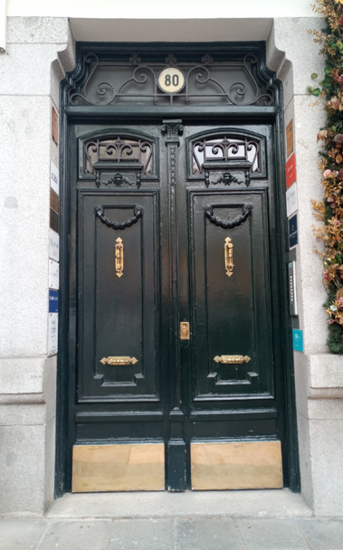 A double set of wooden painted doors with brass finishings and metal details that are just the right level of elegance without being too much