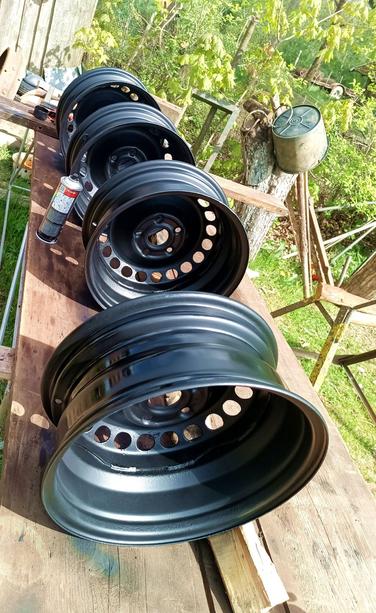 A few weeks later (distractions, distractions), the four wheels are all cleaned up and painted standing on the table with a can of spraypaint.