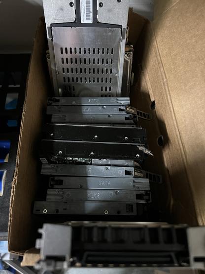 Photo of a box of hard disks. All different shapes and sizes. SATA, SAS, IDE and more.