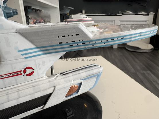Saucer edge decal of dark blue lines. Some excess has went on the pylon. This will be trimmed and removed.