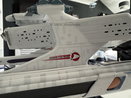 Closeup of a pylon with a decal that reads “Starship U.S.S. Reliant” between two red stripes.