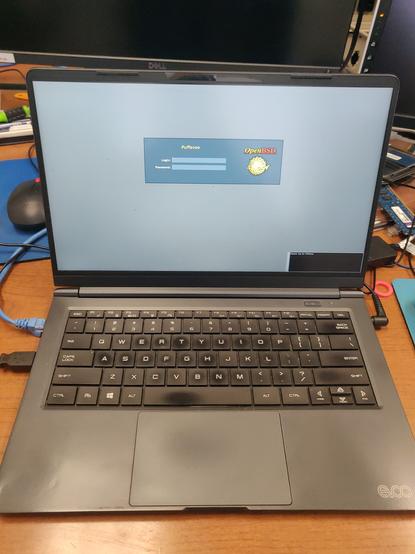 PIcture of my Evoo laptop that runs Windows 11 and OpenBSD, but the screen is now showing the default Xenocara login prompt for OpenBSD.