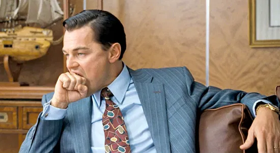 leo dicap in a suit biting he ol' knuckle