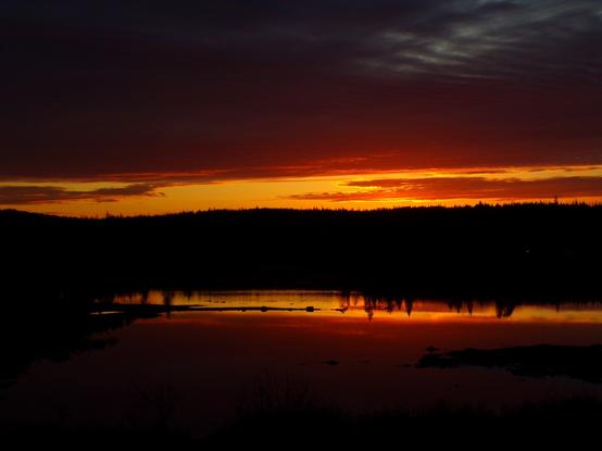 Bright orange against pitch black, the early dawn over the ocean, only the preview of morning makes the rich orange clouds, and the reflection below on the ocean. Everything else is black. It's like Zero Dark Thirty. You were still sleeping and missed this. I got the shot.
