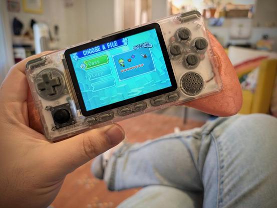 Photo of me playing Zelda on a handheld. My character has eight hearts and two of the elements