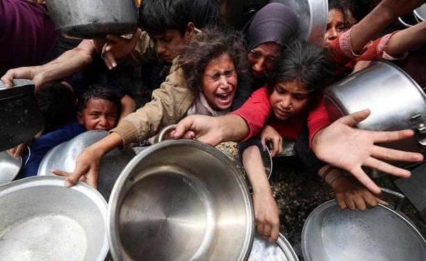 Starving children scramble for food frantically in Jabalia, with despair on their faces. REUTERS/Mahmoud Issa