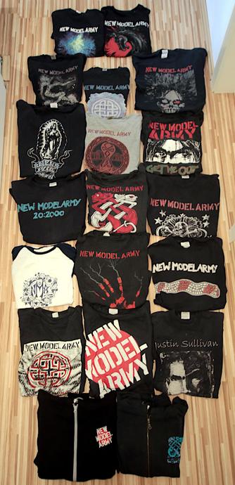 Auf den Bild sind eine zweistellige Anzahl T-Shirts der Band New Model Army zu sehen, die auf dem Boden drappiert sind. Zusätzlich liegen noch zwei Hoodies mit gesticktem Band Logo dort.
