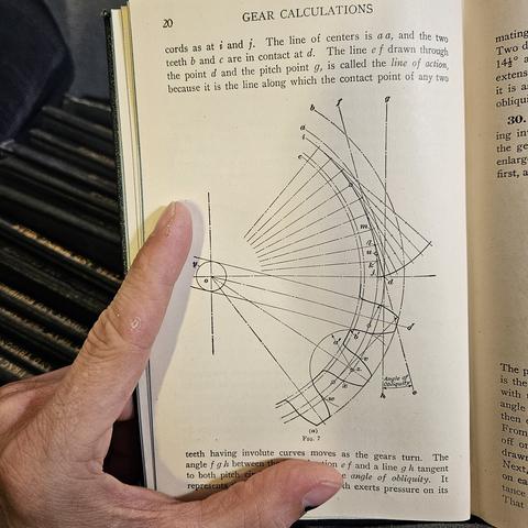 a very intricate geometric construction of a gear in the page of a textbook.