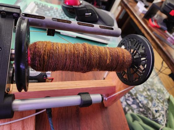 The wool in the rolags is being spun on my electric spinner. The bobbin is about one quarter full, and the colors are all visible, but more blended.