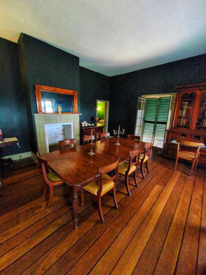 The dining room, featuring a mix of original and period furniture. The walls have been repainted in the room's original forest green colour.