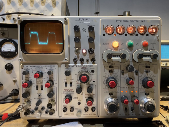 An analog sampling cathode ray oscilloscope with a Nixie tube readout displaying the frequency of the waveform.