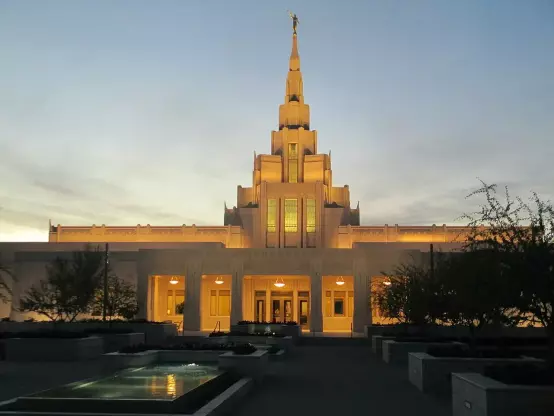 This image appears to show a temple, likely belonging to The Church of Jesus Christ of Latter-day Saints (LDS Church). The building features a tall spire, illuminated warmly during dusk, surrounded by landscaped grounds. If you have any specific questions about it, feel free to ask!

Image Credits: Wikimedia / PoizonMushro0m / CC BY-SA 4.0