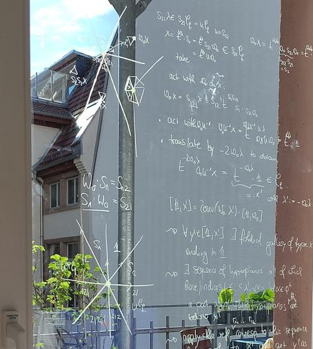 Pieces of math scribbles on a glass door leading to a balcony
