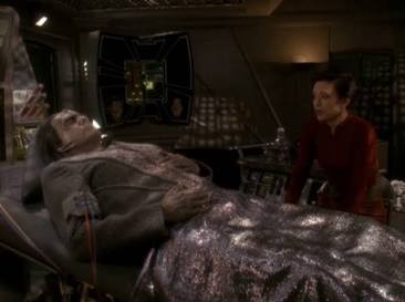 Tekeny, Kira’s Cardassian father-like figure, lying in bed in sickbay with Kira nearby