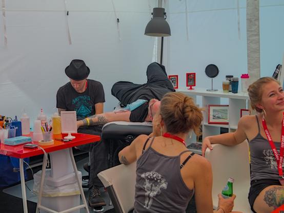 Someone getting a tattoo at Ducati Island during the 2014 MotoGP