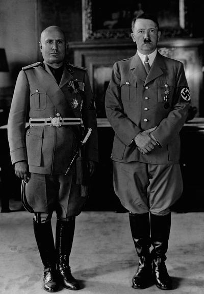 Mussolini and Hitler, 19 June 1940; B&W photo of Benito Mussolini and Adolf Hitler, both in uniform and stone-faced, standing next to one another
