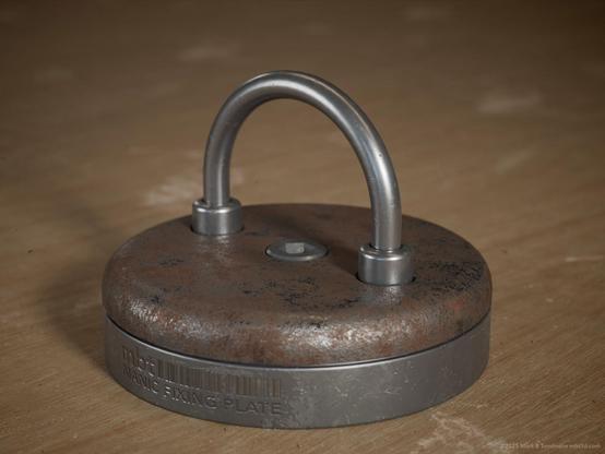 circular disk plate in two halves joined by a hex bolt and a looped metal half ring sitting atop.