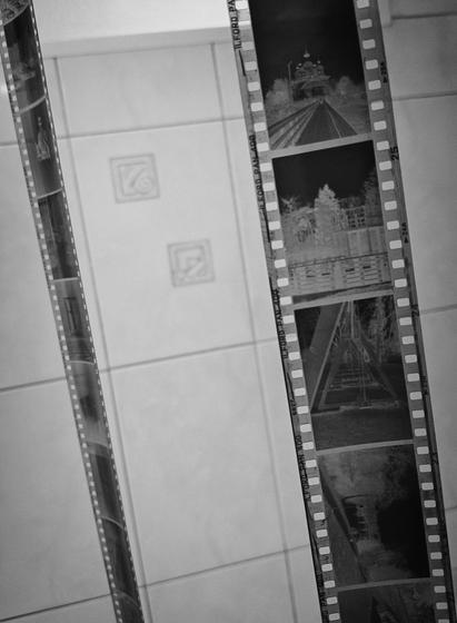 In the monochrome photo, the negatives are hanging in the bathroom.