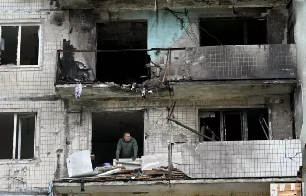 A local resident of a damaged residential building looks on as he clears debris following a Russian strike in Kyiv in May 2025, amid the Russian invasion in Ukraine