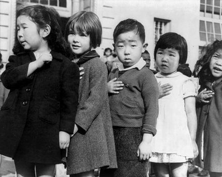 "San Francisco, Calif., April 1942 - Children of the Weill public school, from the so-called international settlement, shown in a flag pledge ceremony. Some of them are evacuees of Japanese ancestry who will be housed in War relocation authority centers for the duration." By Dorothea Lange - https://www.loc.gov/pictures/item/2001705926, Public Domain, https://commons.wikimedia.org/w/index.php?curid=16852192