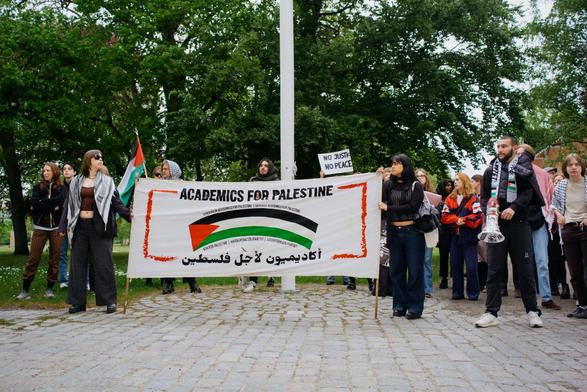 A group of protesters standing with "Academics for Palestine" banner.