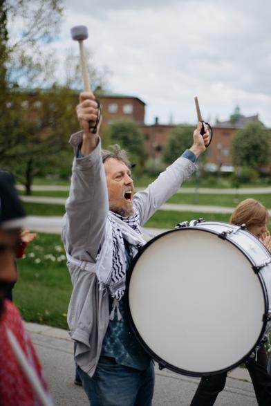 A drummer in the protest march shouting slogas.