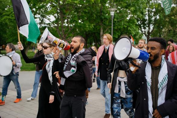 Two megaphones in sync and a lot of other protesters walking together in the march.