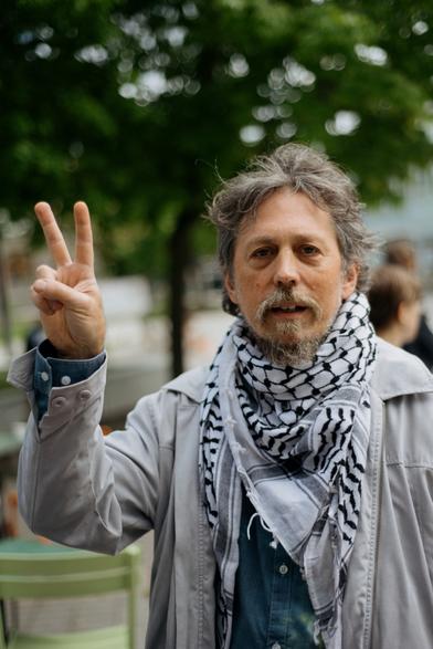 A scientist (wearing keffiyeh around neck) showing victory sign before the protest march.