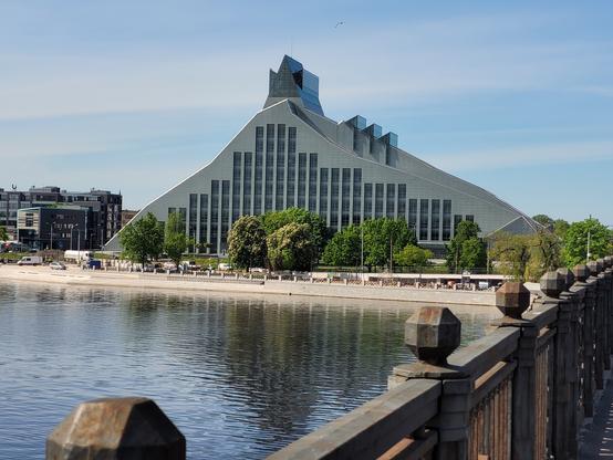 Picture of the library building across from the West Dvina, shaped like a modern glass and steel huge triangle with some smaller fish-fin like thingies on top and sides.