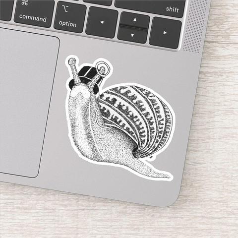 product image of a custom cut sticker on the empty space in the corner under a laptop keyboard, the sticker is of a pen and ink drawing of a snail with a very intricate shell wearing a top hat and monocle.