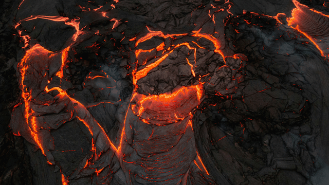 Fresh lava glows orange-red as it slowly cools and solidifies.