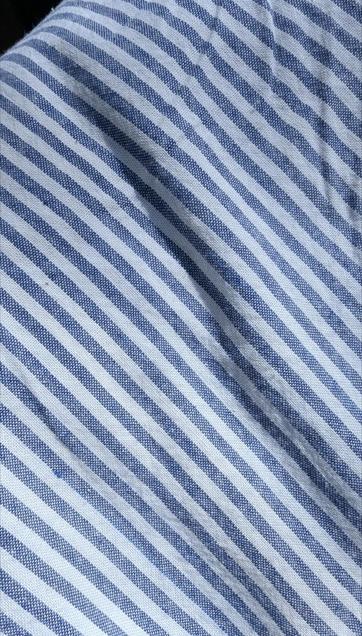 Close photo of blue-and-white striped fabric. It is plain-woven and yarn-dyed, so you can see the mix of white and blue threads if you look closely at the blue stripes.