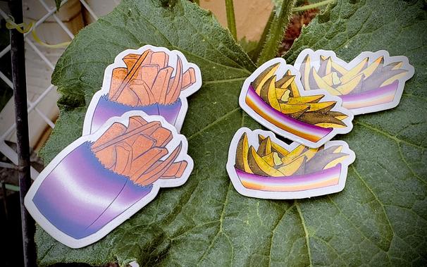 using a cucumber leaf, theres artistically placed stickers. a transgender theme one with sweet potato fries and the other of potato wedges