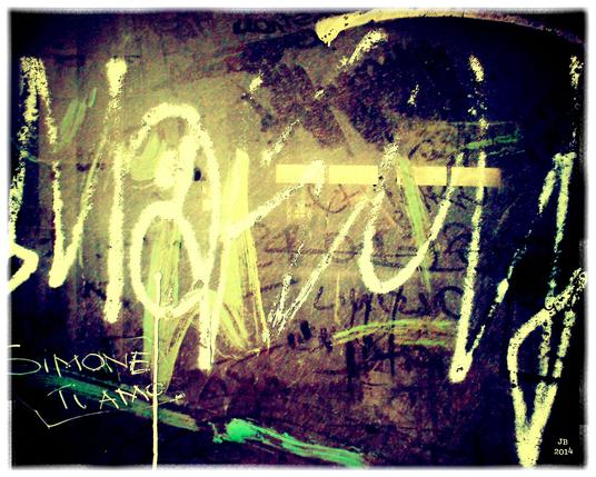 Farbfoto von Graffiti an einer verschmutzten Fensterscheibe in Rom. Schriftartige Formen, deren Bedeutung unklar bleibt. Ausnahme: "SIMONE TI AMO" - "Simone ich liebe dich".