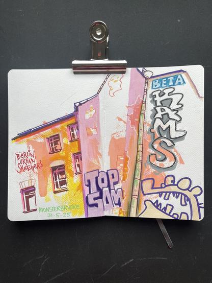 An open sketchbook with a sketch of a house front, some windows and graffiti.