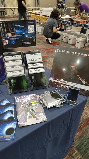 Convention table set up with CDs, cassettes, and vinyl records for sale