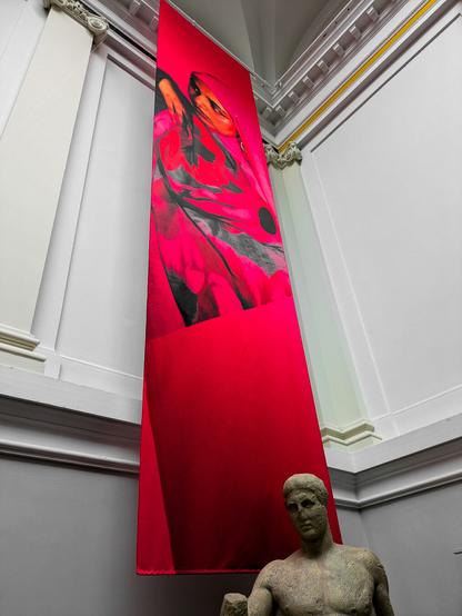 A brightly coloured banner with a classical statue at its base.