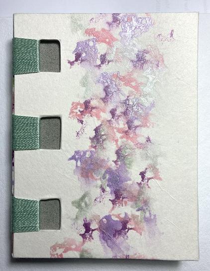 Variante de reliure criss cross. Le plat est recouvert d'un papier Wenzhou  portant un motifs à l'encre : mauve, pourpre, rose, vert mousse .  Le plat montre trois fenêtre rectangulaires  d'où partent vers le dos du livre des fils verts serrés les uns à côté des autres.
Les fenêtres laissent paraître un papier de couleur gris vert.