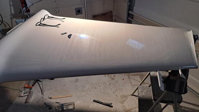 Glancing light shows that the vertical fin on the fuselage has been scraped all over. The tops of orange peel bumps have been removed.