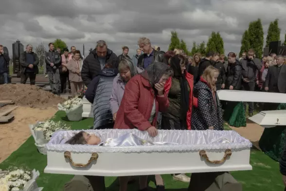 Relatives and friends mourn over the coffins of Roman Martyniuk, 17, his sister Tamara, 11, and brother Stanislav, 8, killed by a Russian missile strike, during a funeral in Korostyshiv, Zhytomyr Oblast, Ukraine, May 2025