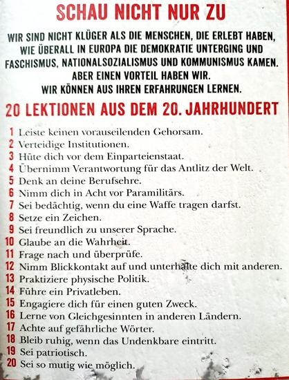 Das Bild zeigt die Rückseite des Taschenbuchs mit den 20 Kapitelüberschriften als die Thesen des Buches.
--------
SCHAU NICHT NUR ZU  
WIR SIND NICHT KLÜGER ALS DIE MENSCHEN, DIE ERLEBT HABEN, WIE ÜBERALL IN EUROPA DIE DEMOKRATIE UNTERGING UND FASCHISMUS, NATIONALSOZIALISMUS UND KOMMUMISMUS KAMEN, ABER EINEN VORTEIL HABEN WIR. WIR KÖNNEN AUS IHREN ERFAHRUNGEN LERNEN. 
-
20 LEKTIONEN AUS DEM 20. JAHRHUNDERT 
-
1 Leiste keinen vorauseilenden Gehorsam  
2 Verteidige Institutionen. 
3 Hüte dich vor dem Einparteienstaat.
4 Ubernimm Verantwortung für das Antlitz der Welt.  
5 Denk an deine Berufsehre.  
6 Nimm dich in Acht vor Paramilitärs.  
7 Sei bedachtig, wenn du eine Waffe tragen darfst.  
8 Setze ein Zeichen. 
9 Sei freundlich zu unserer Sprache. 
10 Glaube an die Wahrheit  
11 Frage nach und überprüfe.
12 Nimm Blickkontakt auf und unterhalte dich mit anderen.
13 Praktiziere physische Politik.
14 Führe ein Privatleben.
15 Engagiere dich für einen guten Zweck.
16 Lerne von Gleichgesinnten in anderen Ländern.
17 Achte auf gefährliche Worter.
18 Bleib ruhig, wenn das Undenkbare eintritt.
19 Sei patriotisch.
20 Sei so mutig wie möglich. 
--------