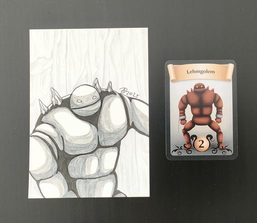 Links seht ihr den Golem traditionell gezeichnet in schwarz-grau-weiß. Er hat einen massigen Körper aus Lehm, einen runden Kopf und an seinen Handgelenken sind Eisenschellen mit einer abgerissenen Eisenkette, als hätte er wäre er mal gefangen gewesen. 
Rechts sehr ihr die Spielkarte in Farbe.