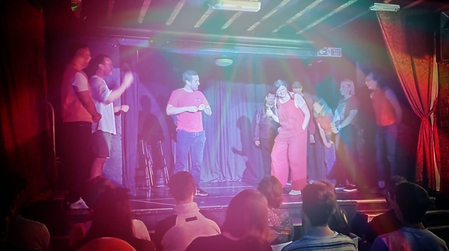 A stage full of performers mostly dressed in red.